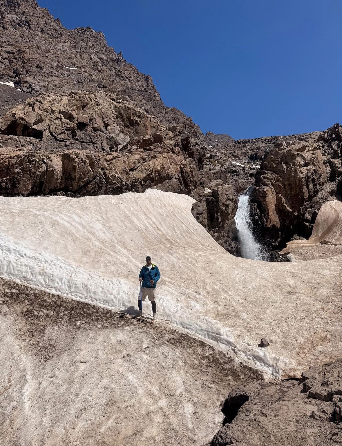Mountain rescue helicopter flying over snowy High Atlas peaks in Morocco